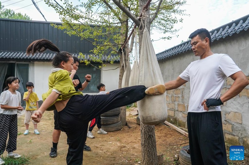 Liu Long (kulia) akimwelekeza binti yake Liu Yidian kufanya mazoezi ya Kungfu ya China kwenye Kijiji cha Liuzhuang cha Mji wa Pizhou, Mkoa wa Jiangsu, mashariki mwa China tarehe 16, Agosti, 2022.