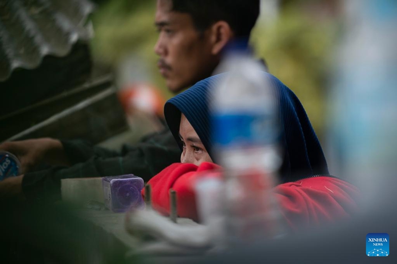Tarehe 24, Novemba, 2022, mwanamke akiangalia waokozi wakitafuta mtoto wake kwenye magofu ya shule ya Kijiji cha Mangunkerta, Cianjur, Mkoa wa West Java wa Indonesia. (Xinhua/Veri Sanovri)