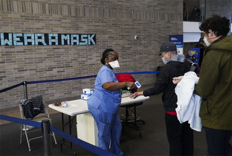 Mhudumu wa afya akipima halijoto ya wageni katika hospitali ya New York, Marekani, Desemba 13, 2021. (Xinhua/Wang Ying)