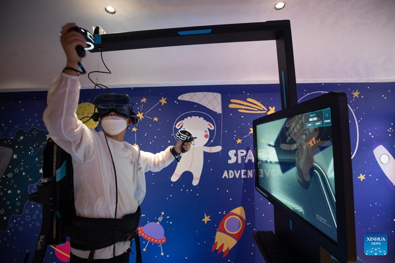 Abiria akicheza kwa kutumia vifaa vya michezo ya kompyuta na kidigitali ndani ya treni ya kitalii katika Mkoa wa Heilongjiang, Kaskazini Mashariki mwa China, Juni 18, 2023. (Xinhua/Zhang Tao)