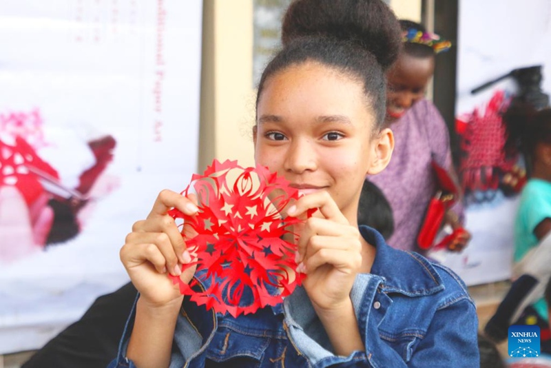 Msichana akionyesha kazi yake ya Sanaa ya Kichina ya kukata karatasi kwenye maonyesho ya utamaduni wa China huko Kigali, Rwanda, Septemba 23, 2023. (Picha na Huang Wanqing/Xinhua)