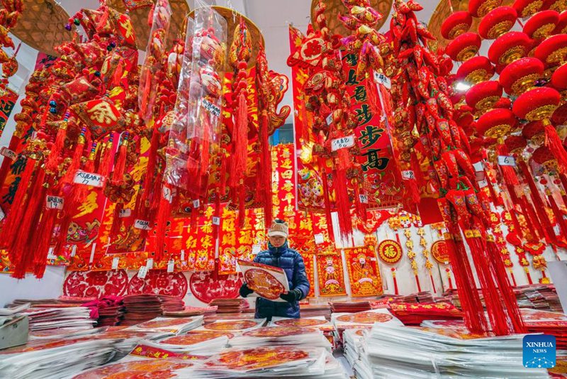 Mteja akichagua mapambo kwa ajili ya mwaka mpya kwa kalenda ya jadi ya China kwenye soko huko Yutian, Mkoa wa Hebei, Kaskazini mwa China, Januari 13, 2024. (Picha na Liu Mancang/Xinhua)