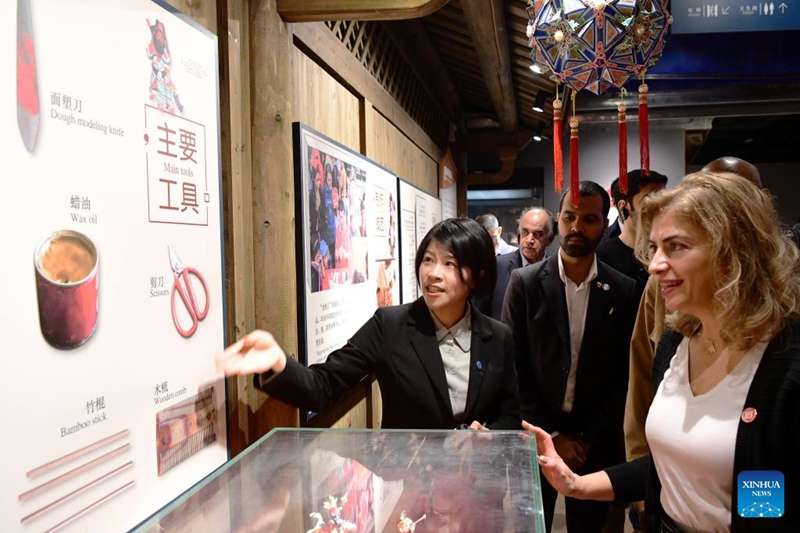 Mabalozi na wanadiplomasia wa nchi za kiarabu nchini China wakifahamishwa mbinu za utengenezaji wa vinyago vya uso , ambazo ni urithi wa utamaduni usioshikika wa kienyeji, katika jumba la makumbusho ya urithi wa utamaduni usioshikika la Quanzhou, Mkoa wa Fujian, kusini mashariki mwa China, Desemba 1, 2024. (Xinhua/Wei Peiquan)