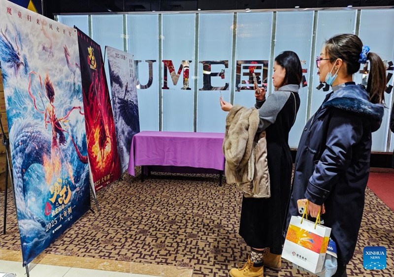 Watu wakiangalia bango la filamu ya “Ne Zha 2” kwenye ukumbi wa sinema mjini Beijing, China, Februari 16, 2025. (Xinhua/Chen Yehua)
